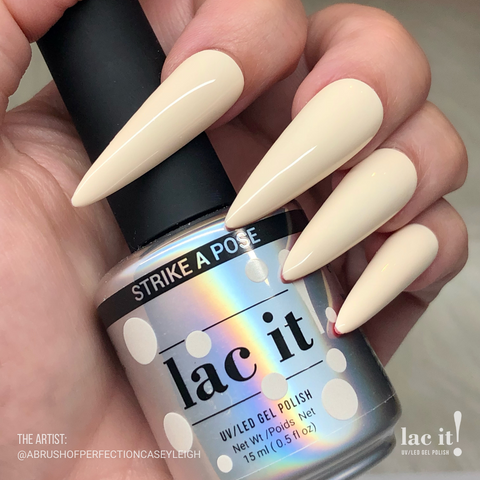 en Vogue Lac It! Strike a Pose off-white, eggshell crème UV/LED gel nail polish for professional nails and extensions on long stiletto manicured nails holding polish bottle