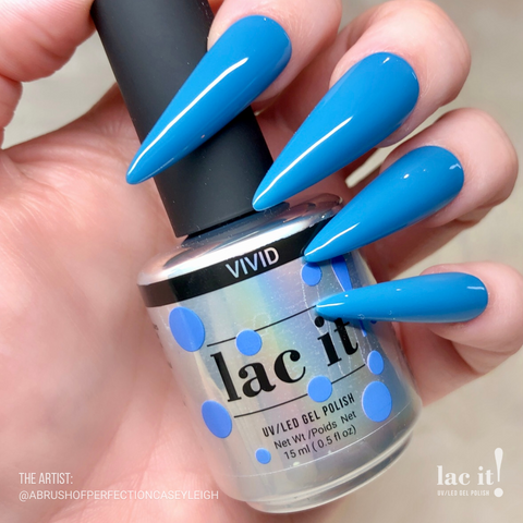 en Vogue Lac It! Vivid 'deep sky blue crème UV/LED gel nail polish for professional nails and extensions on long stiletto shaped manicured nails holding polish bottle